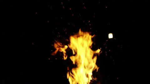 Sparks flying from a fire on a dark background.  Sparks flying from a bonfire at Stock Footage 131502485