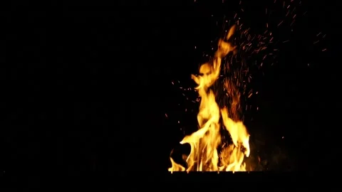 Sparks flying from a fire on a dark background.  Sparks flying from a bonfire at Stock Footage 131503357