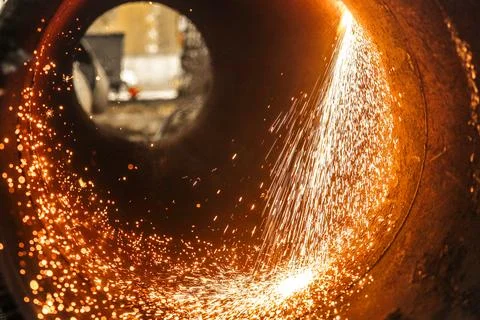 Sparks flying inside a pipe during metal cutting process Stock Photos