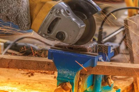 Sparks flying over the working during metal grinding Stock Photos