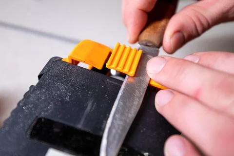 Sparks grinding wheel while knife sharpening. Man sharpens knives on a grinder Foto stock