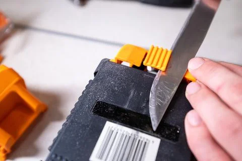 Sparks grinding wheel while knife sharpening. Man sharpens knives on a grinder Stock-Fotos