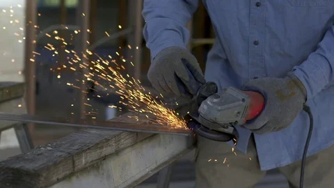 Sparks shower across workshop from angle grinder metal in slow motion HD Stock Footage 80400932