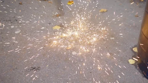 Sparks from the welding are falling down on the asphalt Stock Footage 71647402