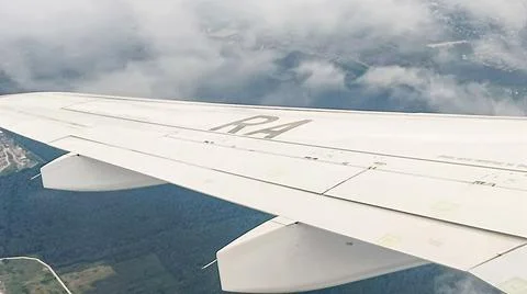 Sparse clouds under the wing of the plane. 库存照片