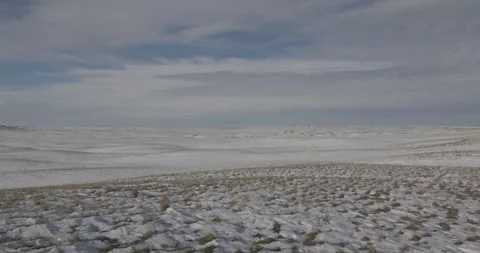 Sparse Snow Across Dry Grassland Under Cloudy Sky Video stock 332378394