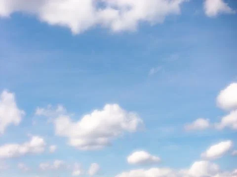 Sparse White Clouds Floating in an Open Blue Sky Stock Photos