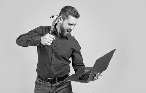 Spate of cyberattack. Hacker assaulting computer with hammer. Targeted Stock-Fotos