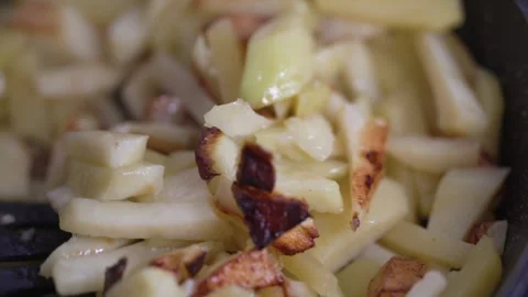 A spatula flips crispy golden fried potatoes in a pan Stock Footage 333517603