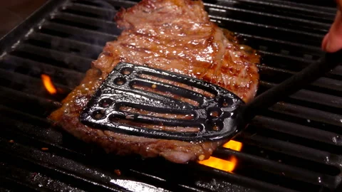 Spatula presses the steak on the hot surface Stock Footage 109104047