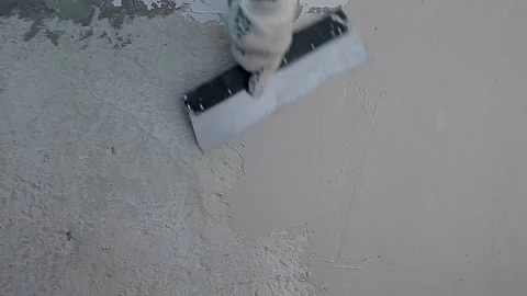 Spatula with putty in hand. Worker puts of plaster on wall. Repair work Stock Footage 133334002