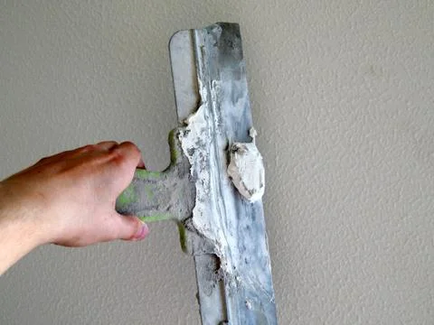 With a spatula putty the wall Stock Photos