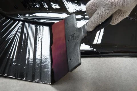 Spatula work on bitumen Stock Photos