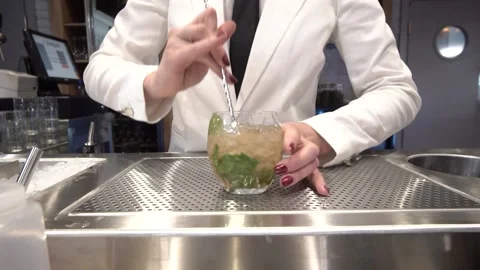 Speakeasy bartender making cocktail, stirring liquor with bar spoon. Stock Footage 217426430