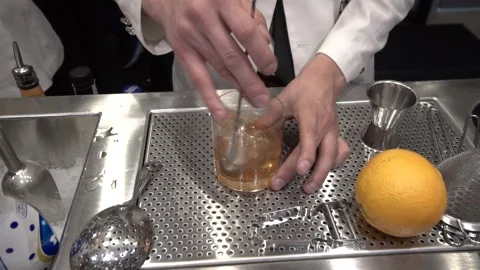 Speakeasy bartender making cocktail, stirring liquor with bar spoon. Stock Footage 217426693