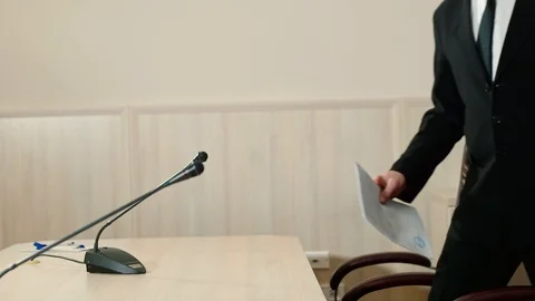 Speaker and his assistant take their places at the microphones, side view Stock Footage 101968916