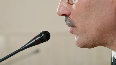 Speaker checks the microphone before speaking and speak, face close-up, side Video stock 101967931