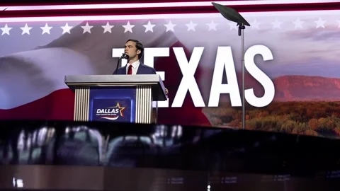 A speaker at the 'Dallas' lectern in front of a giant 'Texas' backdrop Stock Footage 345271482