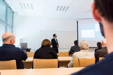 Speaker interacting with the audience at presentation. Stock Photos