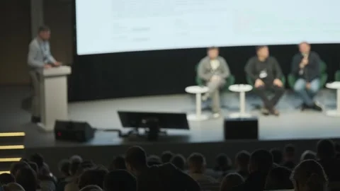 Speaker at podium addresses panel during conference in large the Stock Footage 322089877