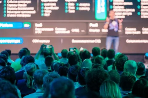 Speaker presenting to audience with technology theme on screen background 写真素材