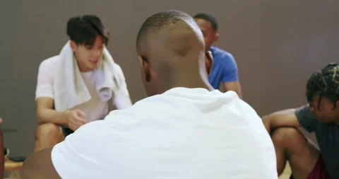 Speaker starting huddle discussing strategy with diverse male basketball Stock Footage 335682744