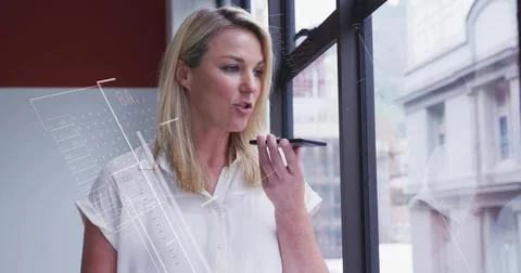 Speaking executive in white blouse issuing commands by window in office, with Foto stock