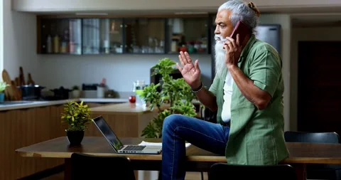 Speaking on smartphone during work, Indian mid age man at home office Stock Footage 342779229