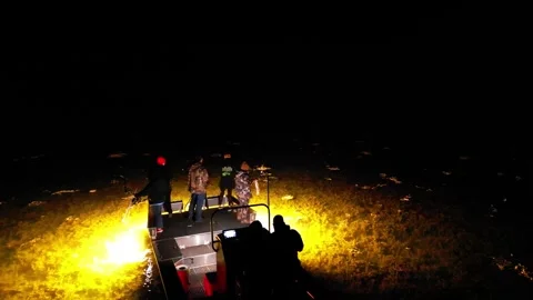 Spearfishers work on a floodlit boat on the Potomac River at night Stock Footage 345299951