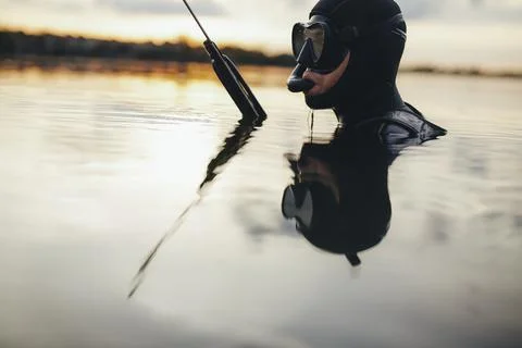 Spearfishing diver submerged in sea water Stock Photos