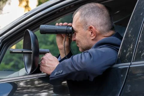 Special agent intercepting conversations with directional microphone during.. Stock Photos