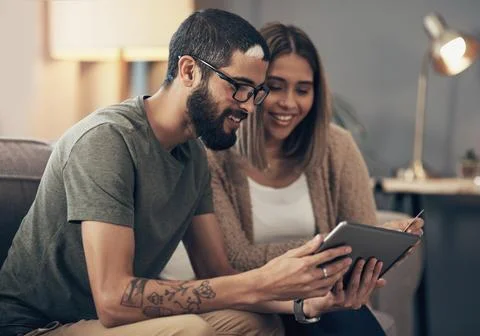 A special and a promo code Score. a young couple using a digital tablet and Stock-Fotos