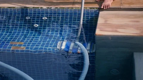 A special brush with a hose cleans the bottom and walls of the pool. slow motion Stock Footage 87209707