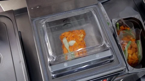 Special device pumps out air from a package with pieces of pumpkin. Stock Footage 88944154