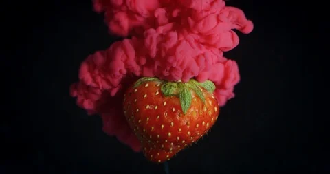 Special effect of a strawberry exploding in a cloud of color on a black backgrou Stock Footage 114712462