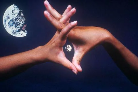Special effects composite of interlaced hands and Earth in black sky Fotos Stock