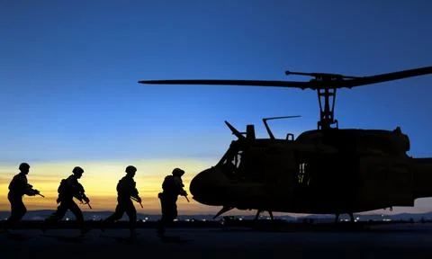 Special force unit running toward to boards military transport helicopter a.. Stock Photos