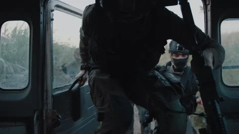 Special forces getting into a moving vehicle near fields outdoors Stock Footage 275090964