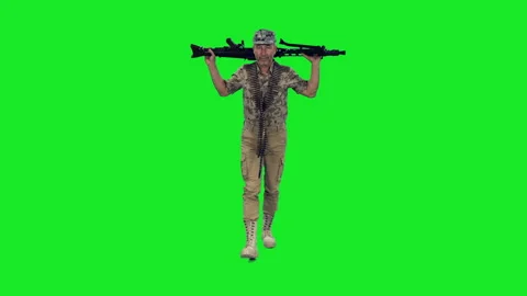 A special forces soldier in camouflage walks with machine gun on green screen Stock Footage 304992853