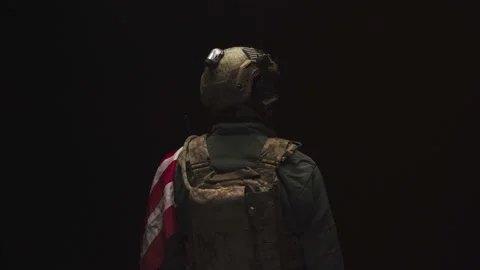 Special forces soldier standing with his back to us in the dark holding USA Stock Footage 150164224