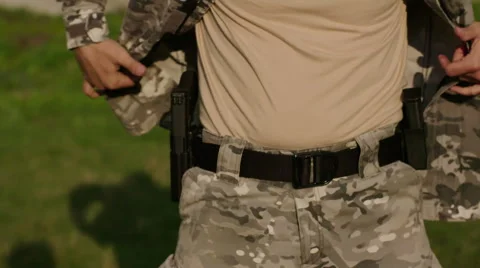 Special forces solider arranging his camouflage suit Stock Footage 64375676