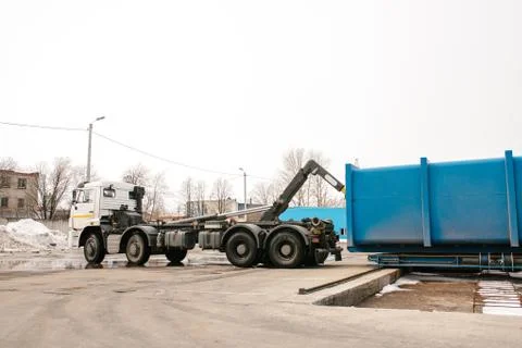 A special heavy machine loads a container with sorted waste. Stock Photos