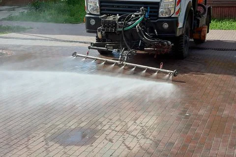 A special machine washes city paths and roads with water Stock Photos