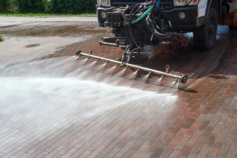 A special machine washes city paths and roads with water Stock Photos