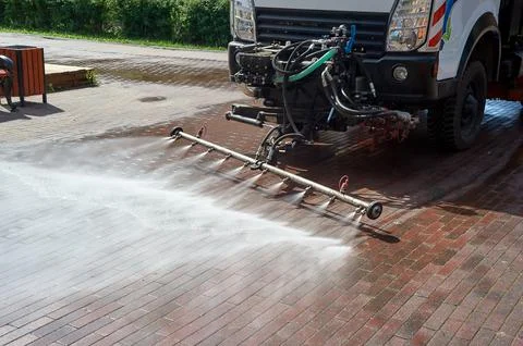 A special machine washes city paths and roads with water Stock Photos