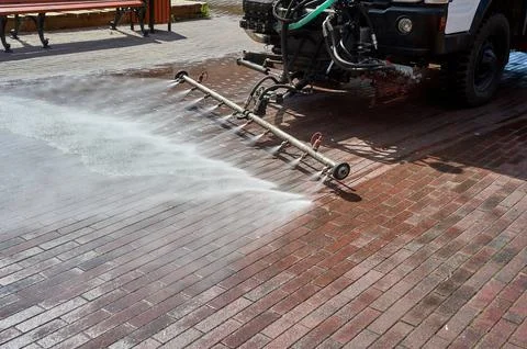 A special machine washes city paths and roads with water Stock Photos
