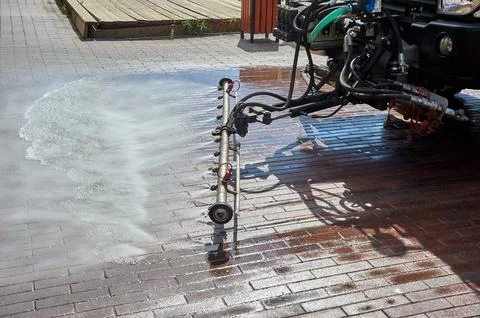 A special machine washes city paths and roads with water Stock Photos