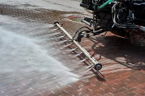 A special machine washes city paths and roads with water Stock Photos