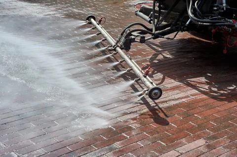 A special machine washes city paths and roads with water Stock Photos