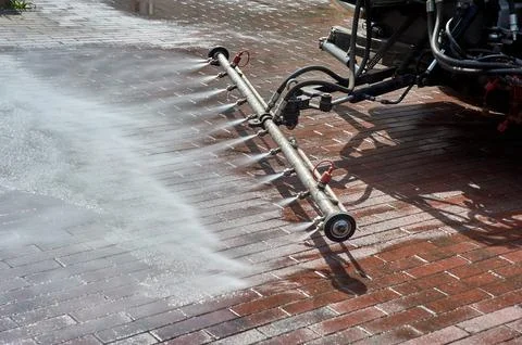 A special machine washes city paths and roads with water Stock Photos